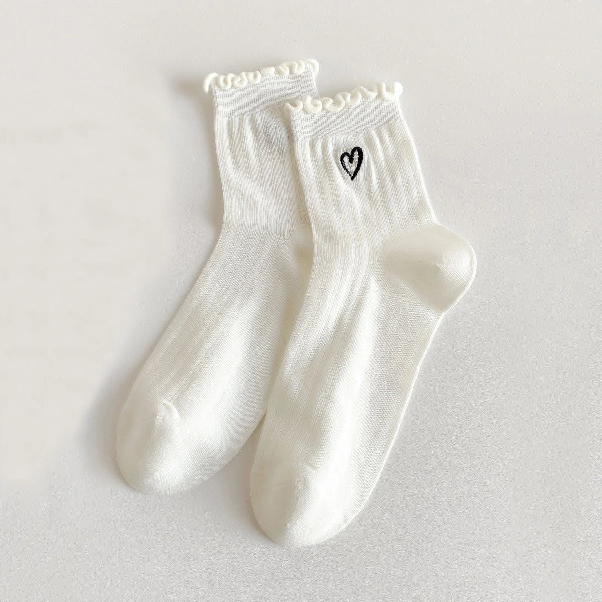 Chaussettes ajourées cœur et feston femme, douces et stretch avec petit cœur brodé. Taille unique 35-41, disponibles en blanc et noir.