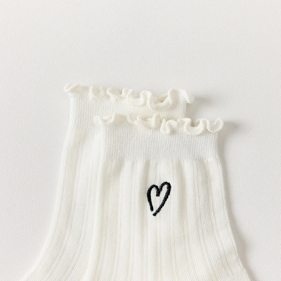 Chaussettes ajourées cœur et feston femme, douces et stretch avec petit cœur brodé. Taille unique 35-41, disponibles en blanc et noir.