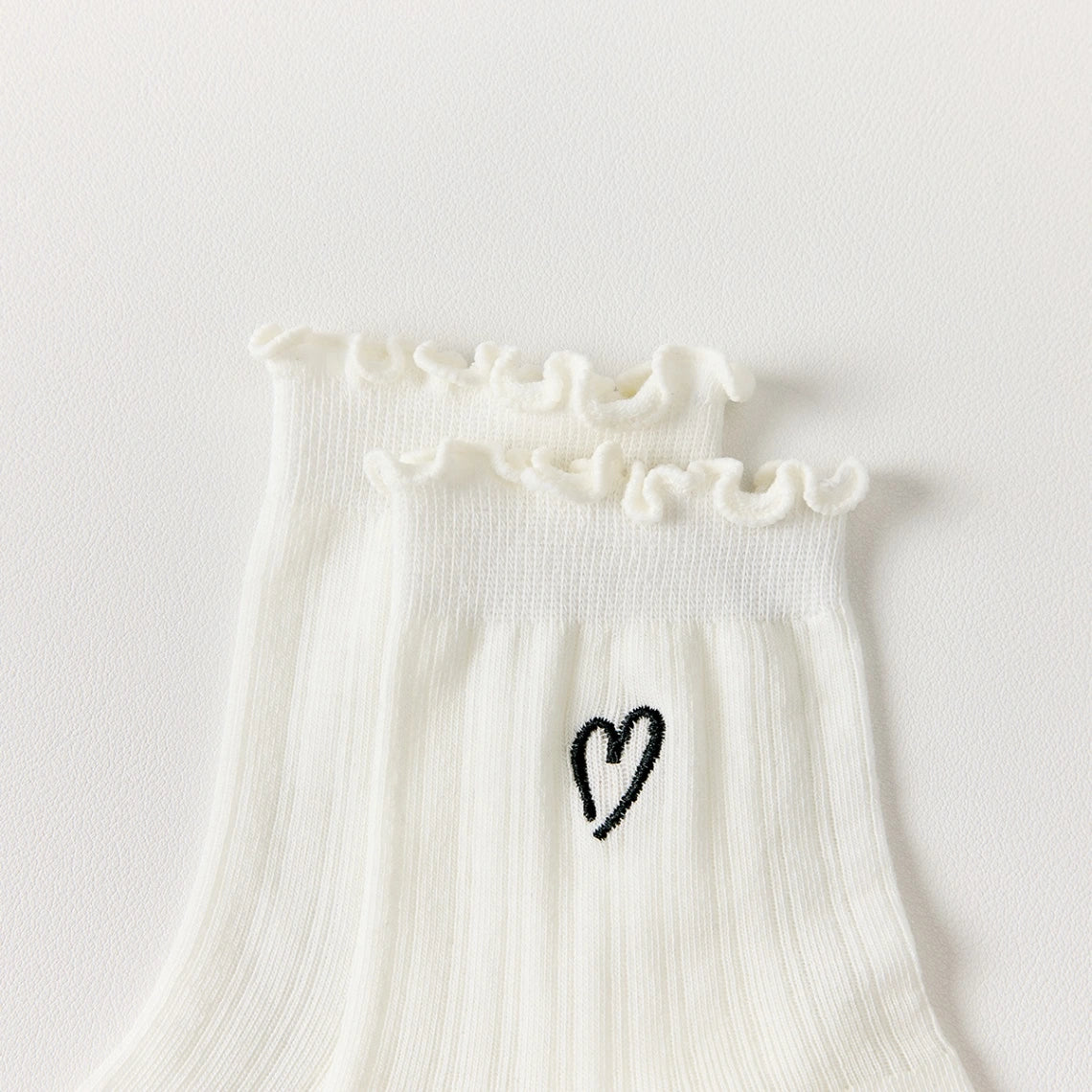 Chaussettes ajourées cœur et feston femme, douces et stretch avec petit cœur brodé. Taille unique 35-41, disponibles en blanc et noir.