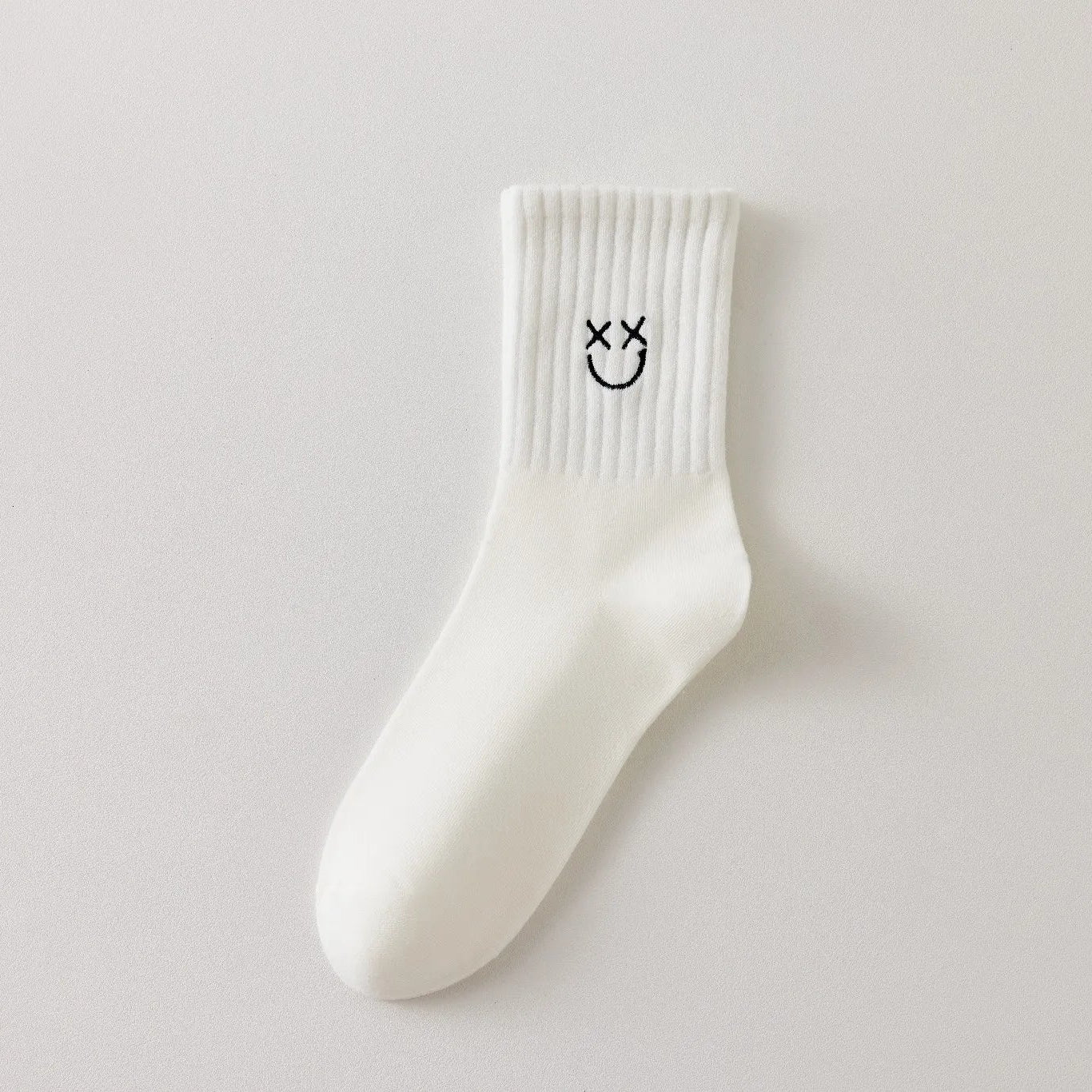 Chaussettes blanches montantes avec smiley, confortables et stylées, idéales avec des baskets. Coton épais, look tendance et maintien optimal.