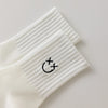 Chaussettes blanches montantes avec smiley, confortables et stylées, idéales avec des baskets. Coton épais, look tendance et maintien optimal.