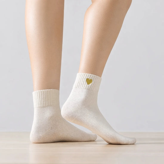 Chaussette haute chaude avec cœur doré brodé.