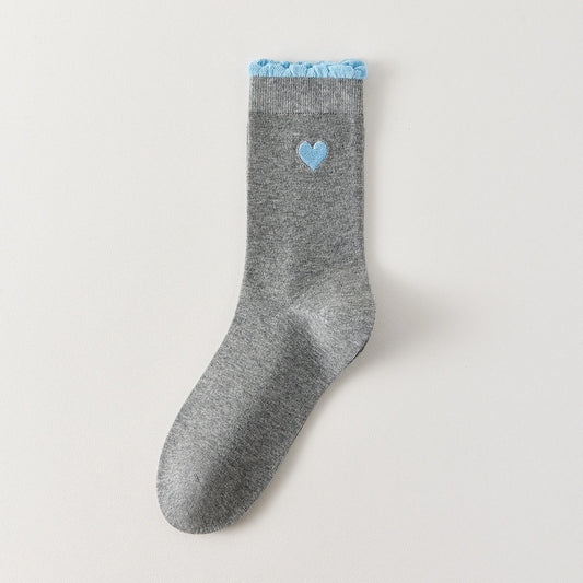 Chaussettes femme montantes avec coeur brodé sur le côté. Haut de tige volanté. Coeur et volant contrastés. 
