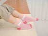 Chaussettes montantes, fond rose, motif licorne. Pour bébé et enfant (du 12 mois au 12 ans).