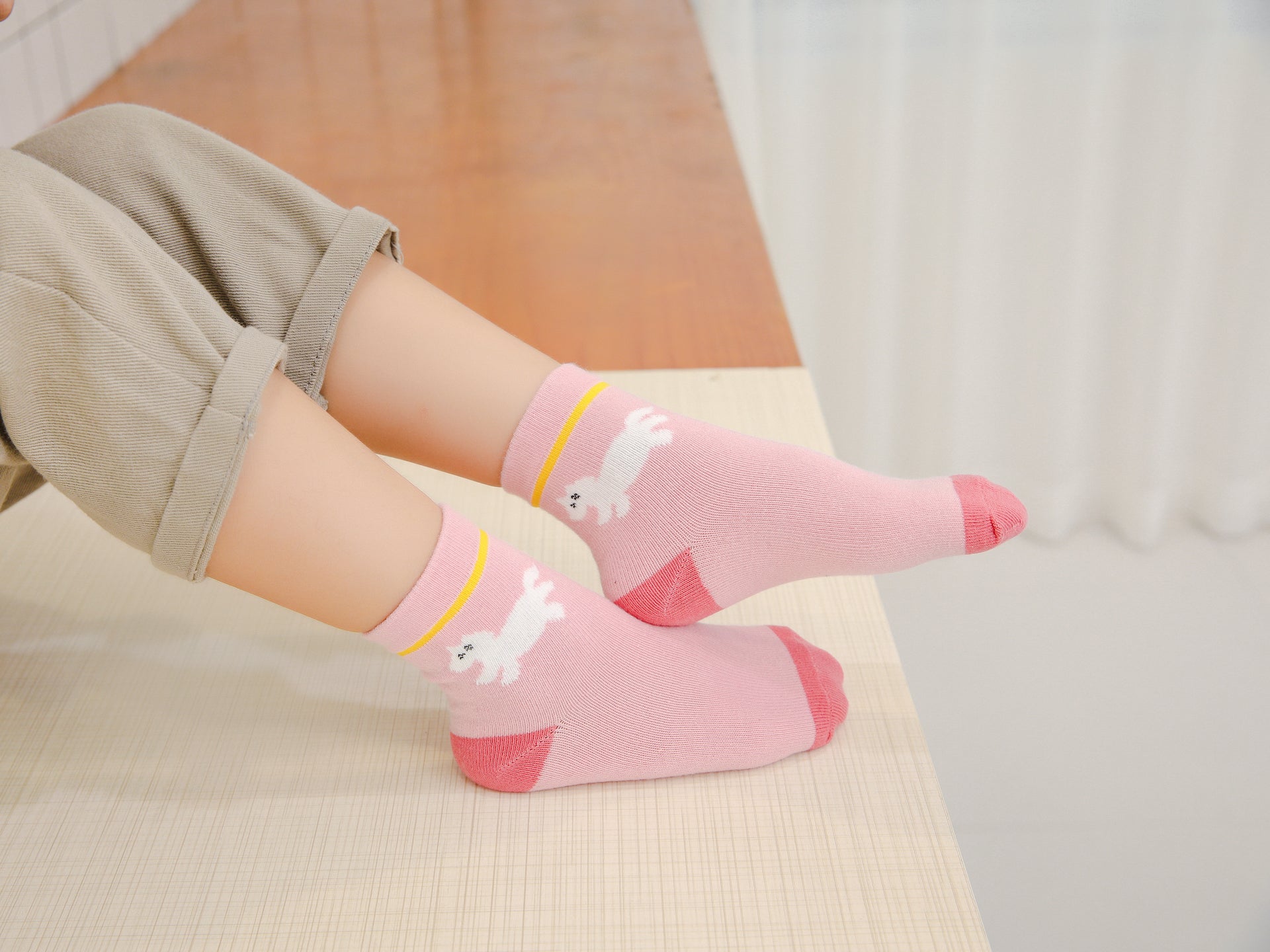 Chaussettes montantes, fond rose, motif licorne. Pour bébé et enfant (du 12 mois au 12 ans).