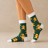 Chaussettes hautes de Noël avec motifs festifs : flocon de neige et bonhomme pain d'épice. Douces, chaudes et stylées pour un hiver cosy et un look joyeux à Noël.