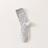 Chaussettes montantes tige côtelée. Motif petit noeud noir. Finition volant sur le haut de tige. Disponibles en blanc, gris chiné clair et noir. 