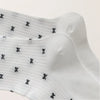 Chaussettes montantes tige côtelée. Motif petit noeud noir. Finition volant sur le haut de tige. Disponibles en blanc, gris chiné clair et noir. 