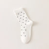 Chaussettes montantes tige côtelée. Motif petit noeud noir. Finition volant sur le haut de tige. Disponibles en blanc, gris chiné clair et noir. 