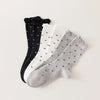 Chaussettes montantes tige côtelée. Motif petit noeud noir. Finition volant sur le haut de tige. Disponibles en blanc, gris chiné clair et noir. 