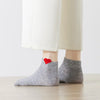 Chaussette unie avec petit cœur rouge brodé.