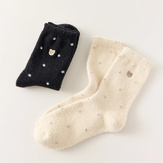 Chaussettes chaudes et douces, effet polaire, motif petits pois, tête d'ours brodée, proposée en noir et blanc cassé.