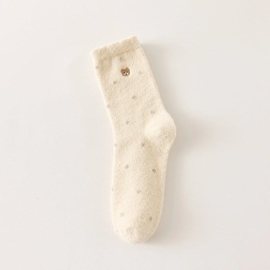 Chaussettes chaudes et douces, effet polaire, motif petits pois, tête d'ours brodée, proposée en noir et blanc cassé.