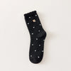 Chaussettes chaudes et douces, effet polaire, motif petits pois, tête d'ours brodée, proposée en noir et blanc cassé.