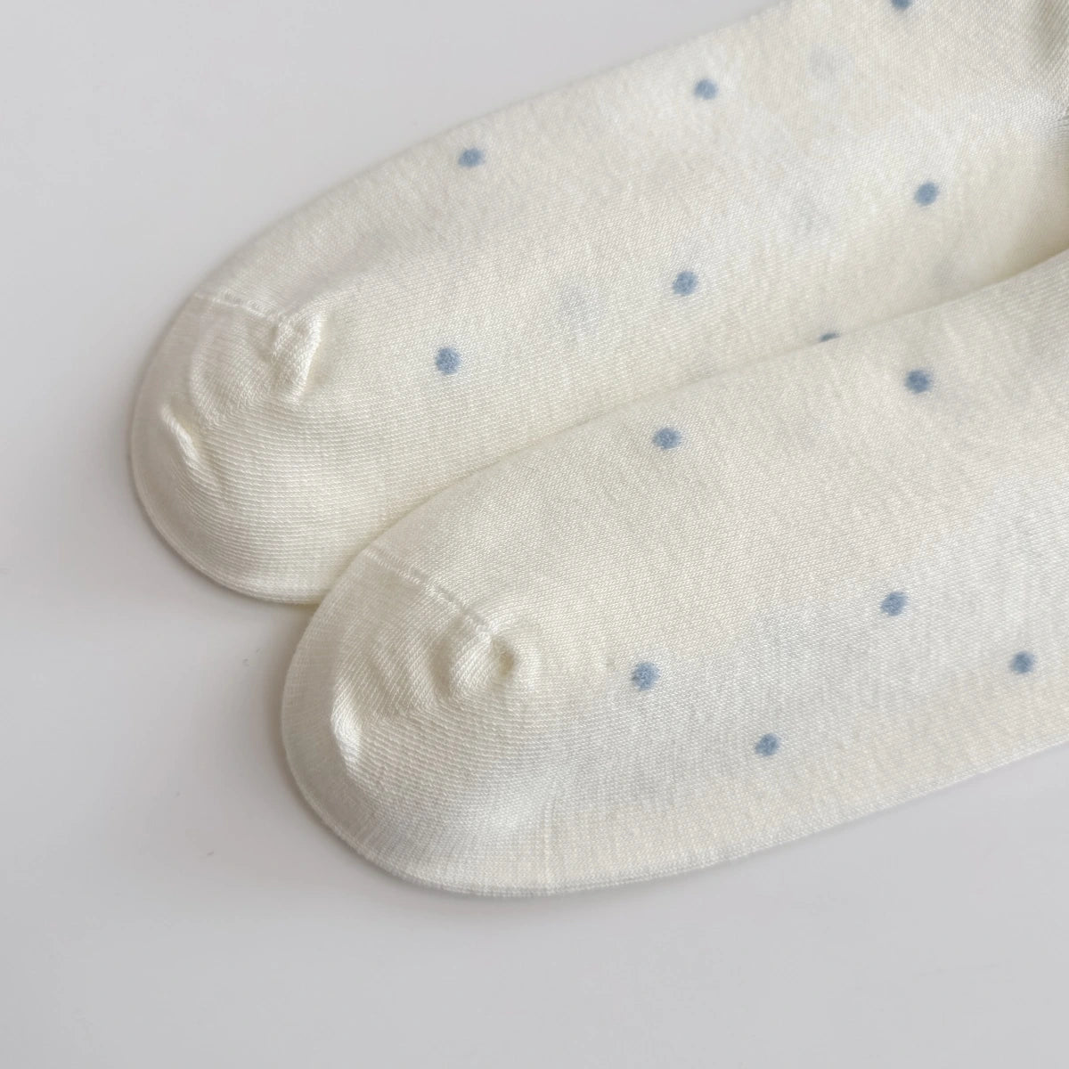 Chaussettes Volant Cœur & Pois femme vendues à l’unité. Modèles blanc à pois bleus ou gris bleu avec volant et cœur brodé. Taille unique 35-41.