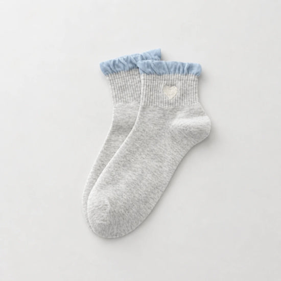 Chaussettes Volant Cœur & Pois femme vendues à l’unité. Modèles blanc à pois bleus ou gris bleu avec volant et cœur brodé. Taille unique 35-41.