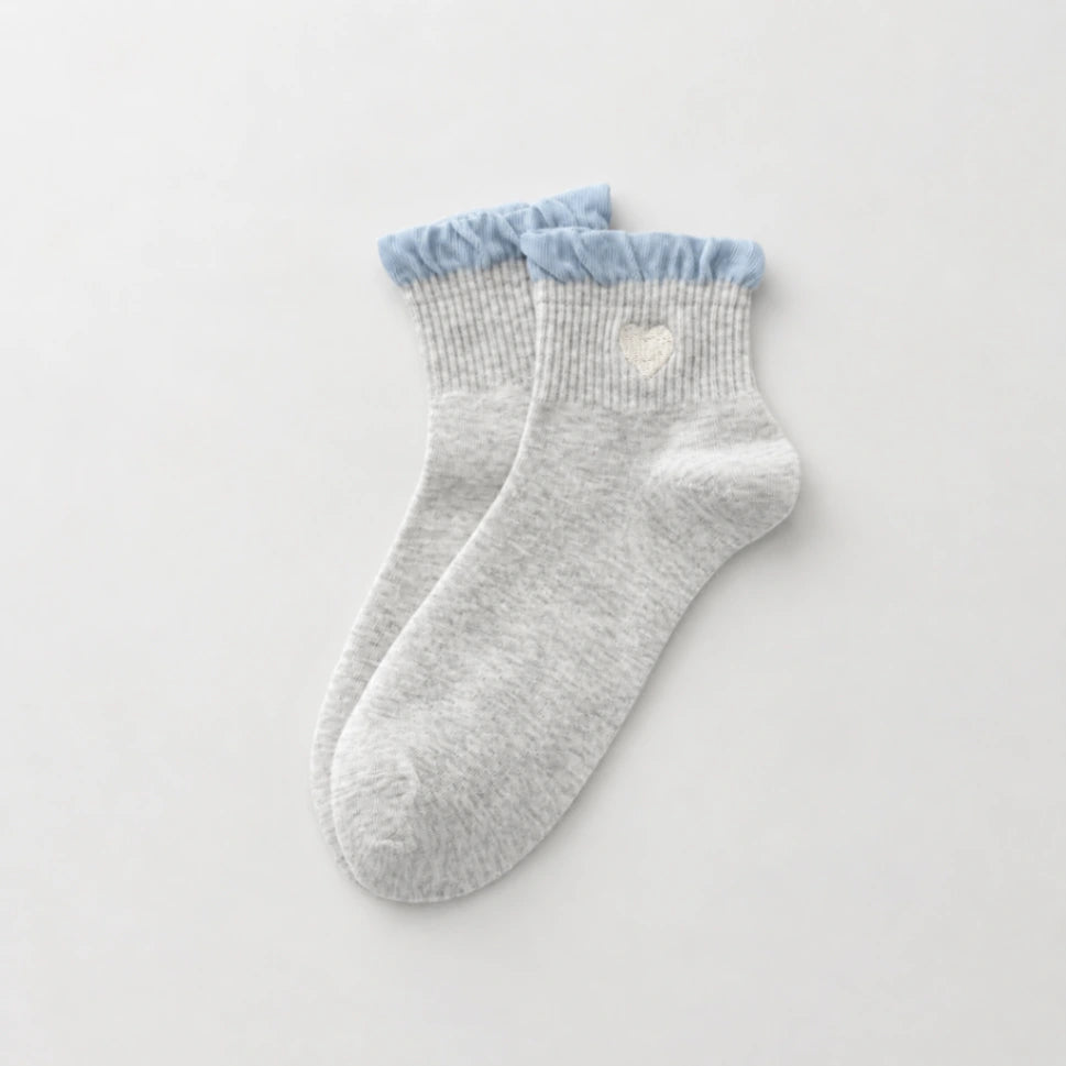 Chaussettes Volant Cœur & Pois femme vendues à l’unité. Modèles blanc à pois bleus ou gris bleu avec volant et cœur brodé. Taille unique 35-41.