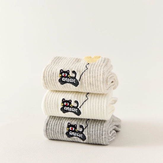 Lot de 3 chaussettes mi-hautes. Motif chat noir tenant un ballon en forme de coeur. Coloris blanc, beige et gris. Coeur contrasté.