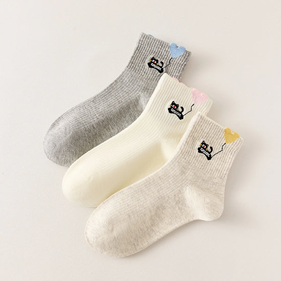 Lot de 3 chaussettes mi-hautes. Motif chat noir tenant un ballon en forme de coeur. Coloris blanc, beige et gris. Coeur contrasté.