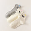 Lot de 3 chaussettes mi-hautes. Motif chat noir tenant un ballon en forme de coeur. Coloris blanc, beige et gris. Coeur contrasté.