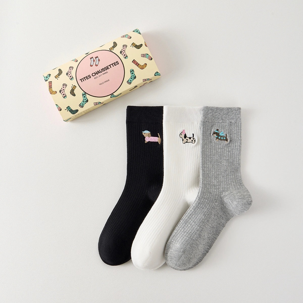 Lot de 3 chaussettes hautes côtelées. Coloris noir, gris chiné, blanc. Broderie petit chien sur l'extérieur du pied. 
