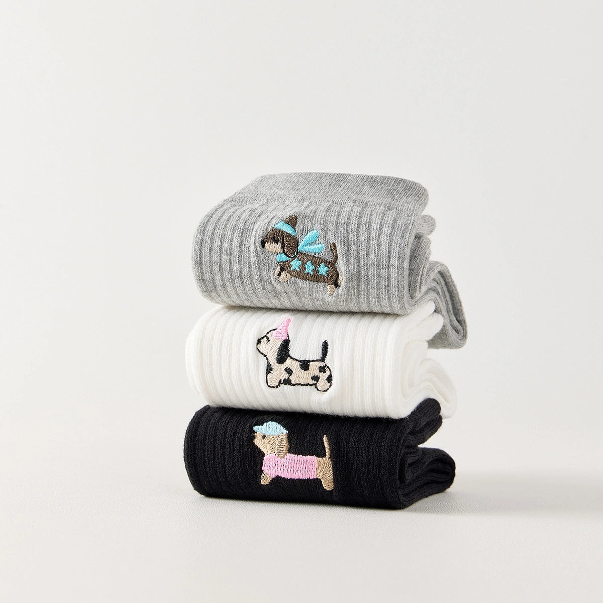 Lot de 3 chaussettes hautes côtelées. Coloris noir, gris chiné, blanc. Broderie petit chien sur l'extérieur du pied. 