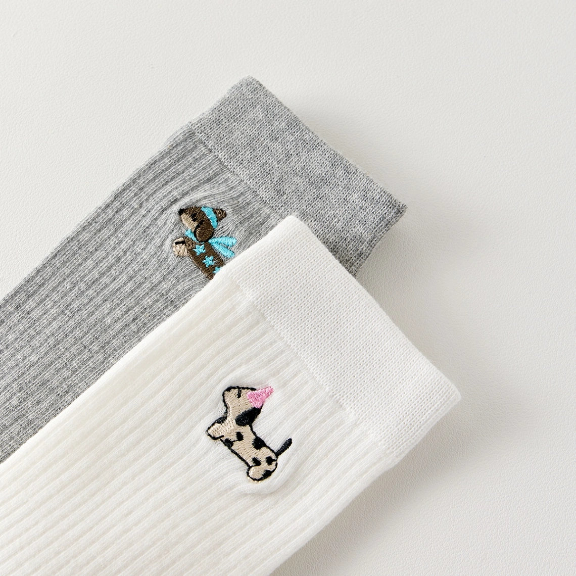 Lot de 3 chaussettes hautes côtelées. Coloris noir, gris chiné, blanc. Broderie petit chien sur l'extérieur du pied. 