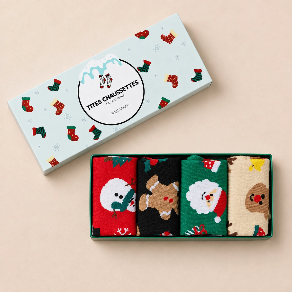 Chaussettes hautes, motifs de Noël : bonhomme de neige, père noël, renne ou biscuit de noël. Coloris festifs : rouge, vert, beige, noir. Douces et Chaudes. Vendues dans leur coffret de Noël. 