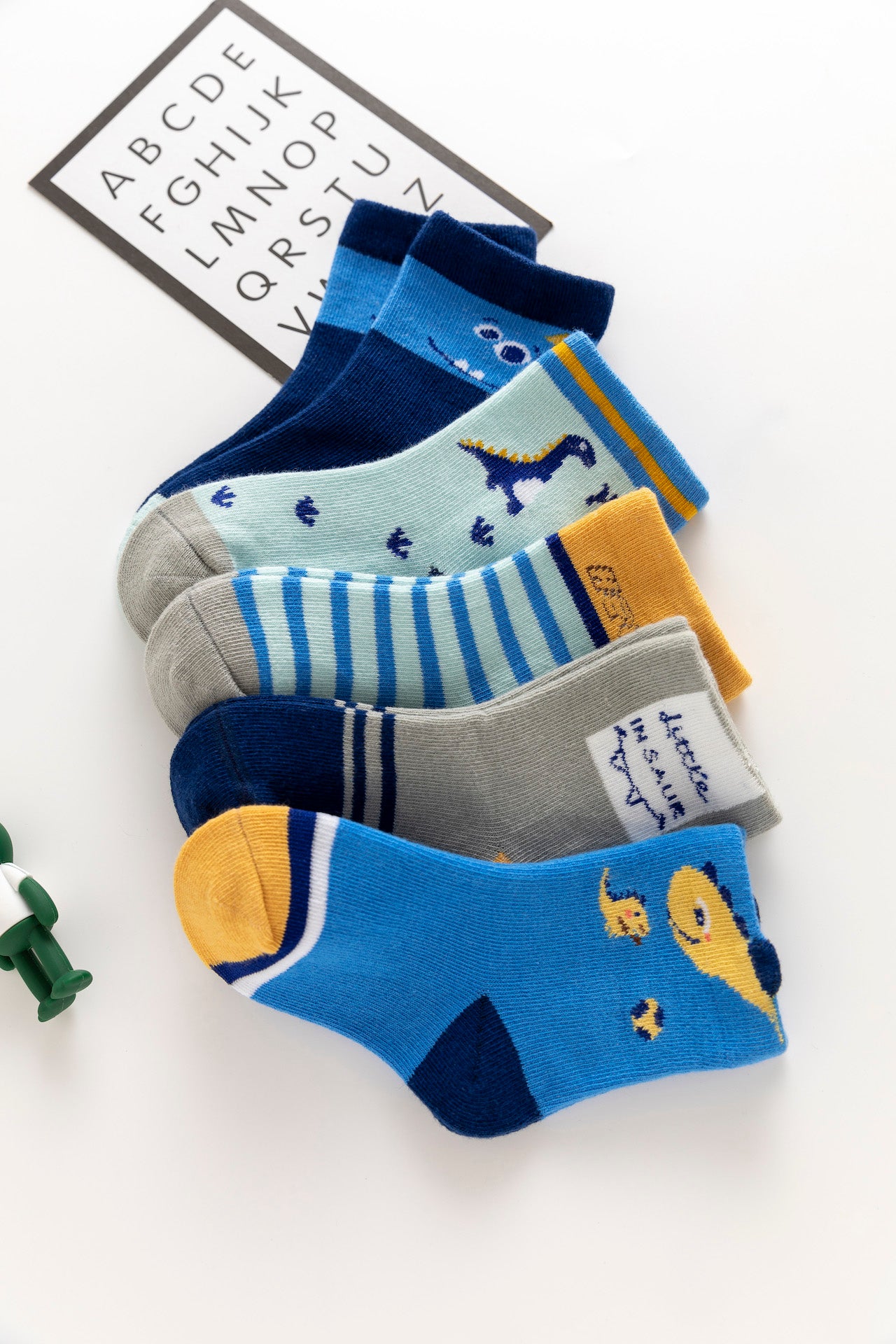 Lot de 5 chaussettes enfant bleues à motifs dinosaures. Confortables, douces et ludiques. Tailles de 12 mois à 12 ans. Parfait pour les petits explorateurs.