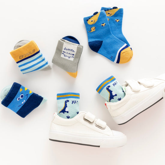Lot de 5 chaussettes enfant bleues à motifs dinosaures. Confortables, douces et ludiques. Tailles de 12 mois à 12 ans. Parfait pour les petits explorateurs.