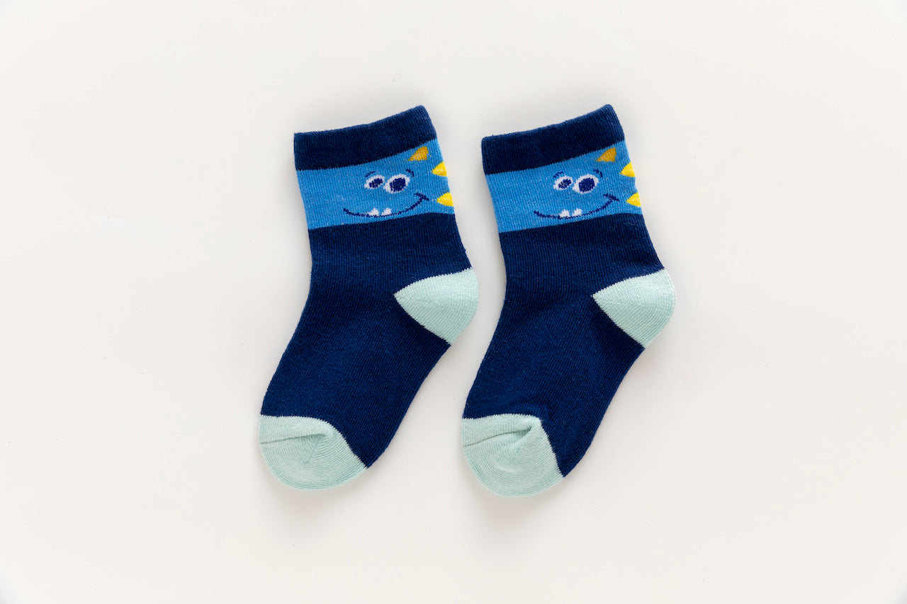 Lot de 5 chaussettes enfant bleues à motifs dinosaures. Confortables, douces et ludiques. Tailles de 12 mois à 12 ans. Parfait pour les petits explorateurs.