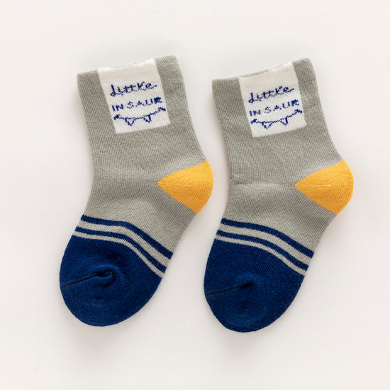 Lot de 5 chaussettes enfant bleues à motifs dinosaures. Confortables, douces et ludiques. Tailles de 12 mois à 12 ans. Parfait pour les petits explorateurs.