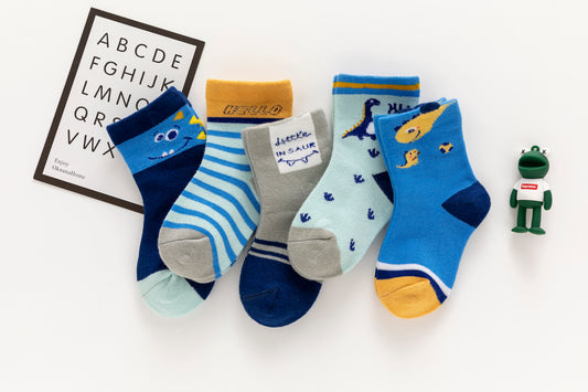 Lot de 5 chaussettes enfant bleues à motifs dinosaures. Confortables, douces et ludiques. Tailles de 12 mois à 12 ans. Parfait pour les petits explorateurs.