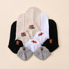 Lot de 5 chaussettes basses. Languettes brodées avec motifs de Noël : pain d'épice, sucre d'orge, teckel de Noël et message Merry Christmas (Joyeux Noël). Coloris : blanc, beige, gris chiné et noir. 