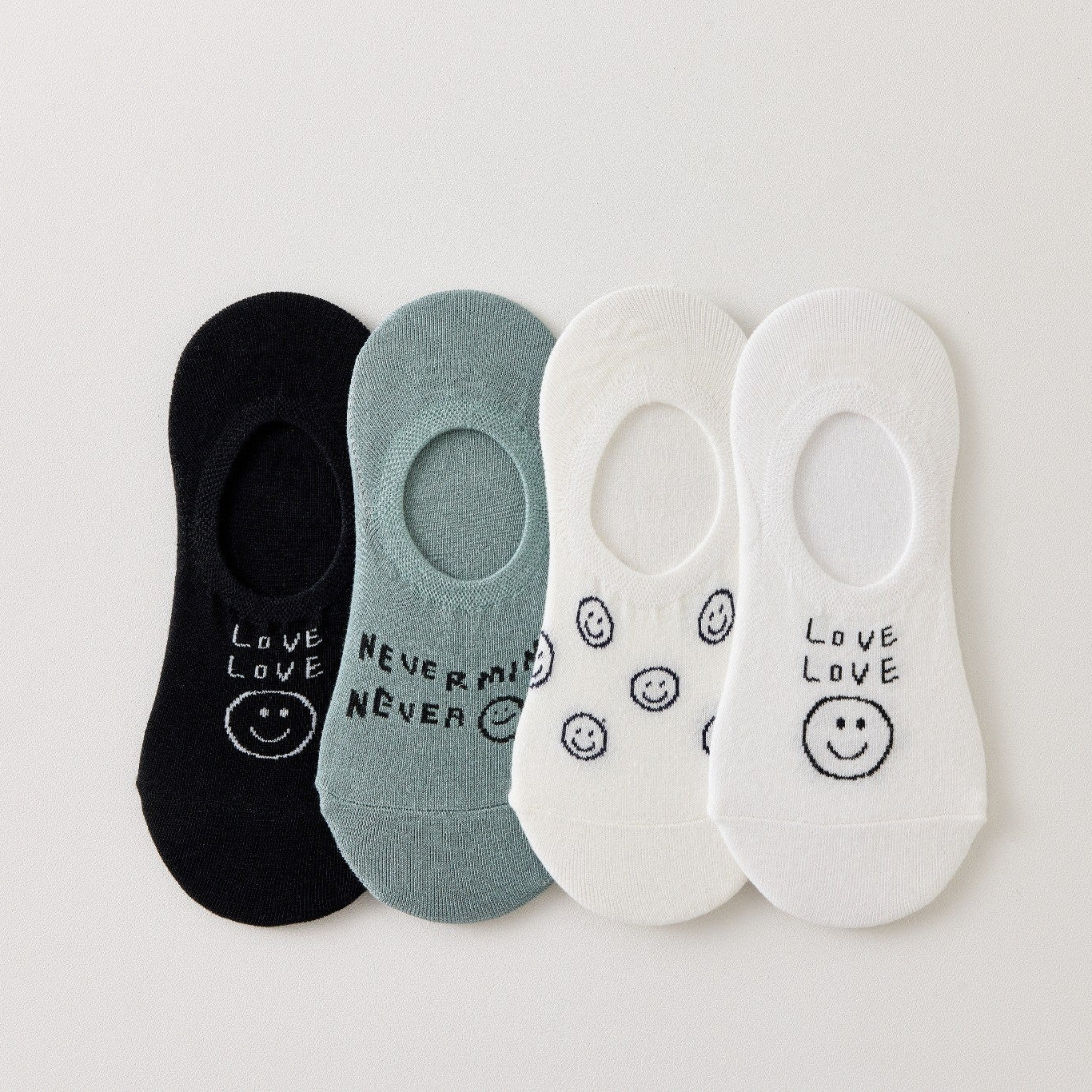 Lot de 4 socquettes invisibles en coton avec motif smiley ou message. Fond noir, blanc ou bleu. Confortables, discrètes et parfaites avec des baskets.